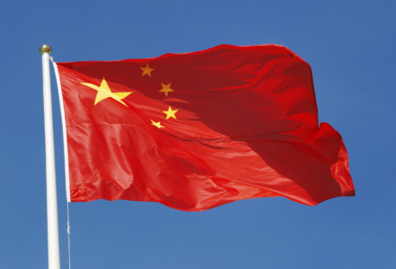 The national flag of the People's Republic of China on blue sky.